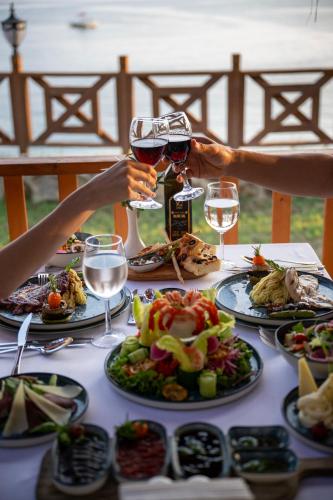 a table with plates of food and glasses of wine at Oz Hotels Incekum Beach in Alanya