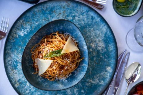 a plate of spaghetti with cheese on a table at Oz Hotels Incekum Beach in Alanya