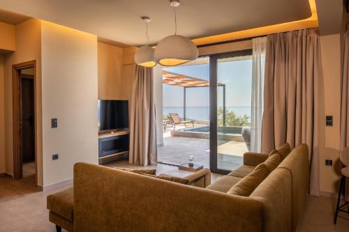 a living room with a couch and a large window at Villa Keras With Sea View in Keratokampos
