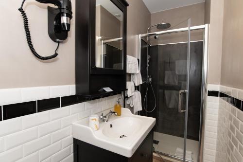 a bathroom with a sink and a shower at The Originals Boutique, Hôtel Victoria, Châtelaillon-Plage in Châtelaillon-Plage