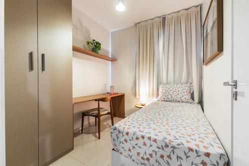 a small bedroom with a bed and a desk at Apto Aconchegante no coracao da Ilhotas in Teresina