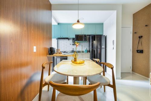 a kitchen with a wooden table and chairs in a kitchen at Apto Aconchegante no coracao da Ilhotas in Teresina