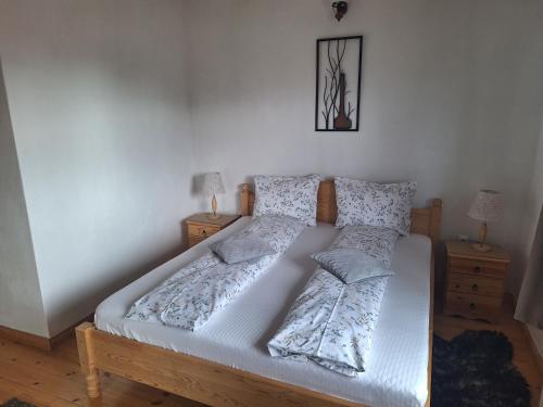 a bedroom with a bed with white sheets and pillows at Casa Oaspeti Transfagarasan in Cîrţişoara