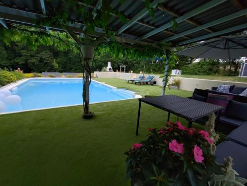 a swimming pool with a table and a bench next to it at Escapades Romantiques Uniques amour amour amour in Loubès-Bernac
