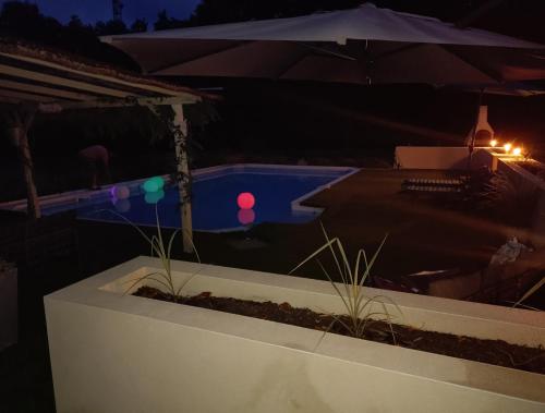 - une piscine avec parasol la nuit dans l'établissement Escapades Romantiques Uniques amour amour amour, à Loubès-Bernac