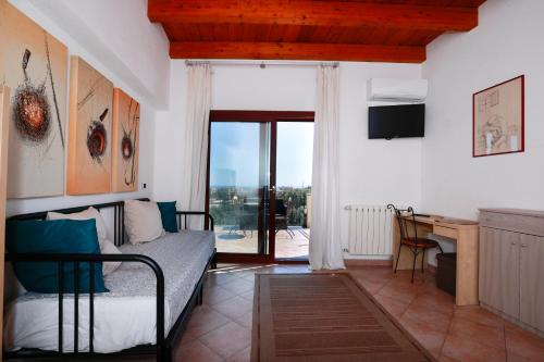 a bedroom with a bed and a desk with a window at la circumetnea rooms in Catania