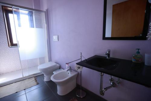 a bathroom with a sink and a toilet and a mirror at la circumetnea rooms in Catania