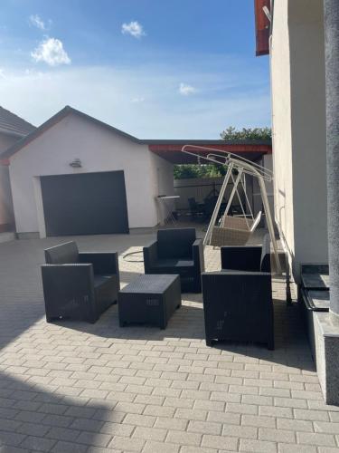 a group of chairs sitting on a patio at Anett Wellis Apartman Poroszló in Pusztavacs