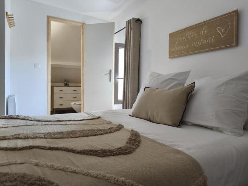 a bedroom with a bed with white sheets and pillows at Maison T2 in Sermaises