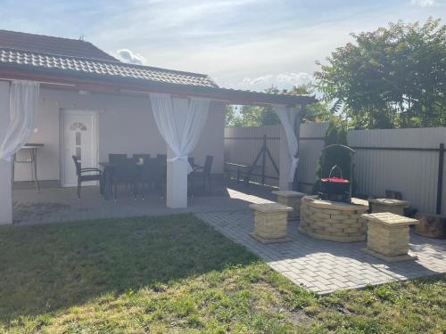 a patio with a gazebo and a table at Anett Wellis Apartman Poroszló in Pusztavacs