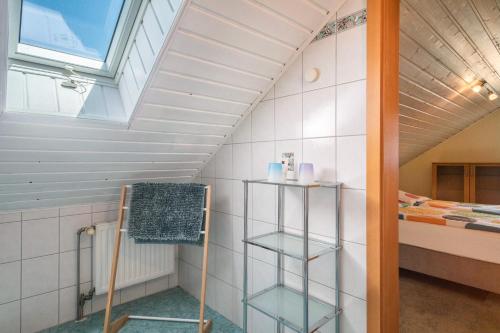 a attic bathroom with a window and a bed at Landhaus Bodensee in Deggenhausertal