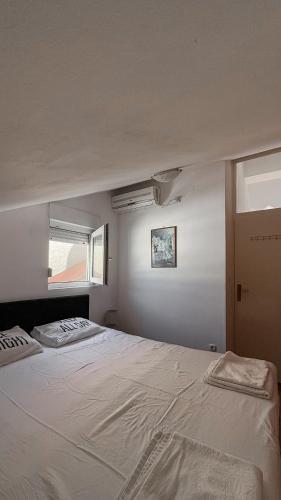 a bedroom with a large white bed with a window at The View Savina - Herceg Novi in Herceg-Novi