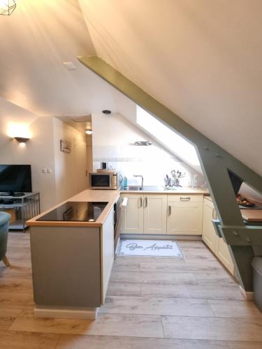 une cuisine mansardée avec un évier et un escalier dans l'établissement HAVRE MARIN DU CENTRE VILLE lumineux, spacieux à 5 min de la plage, à Dinard