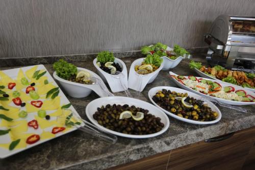 - un buffet avec de nombreuses assiettes de nourriture sur un comptoir dans l'établissement Elips Royal Hotel & SPA, à Antalya