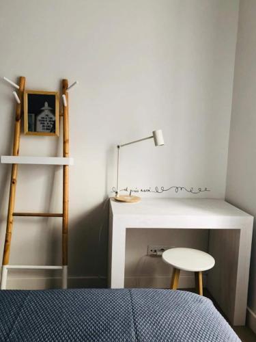 a bedroom with a bed and a desk and a stool at Spacious 3 Bedroom Apartment 20 Min To Lisbon in Montijo