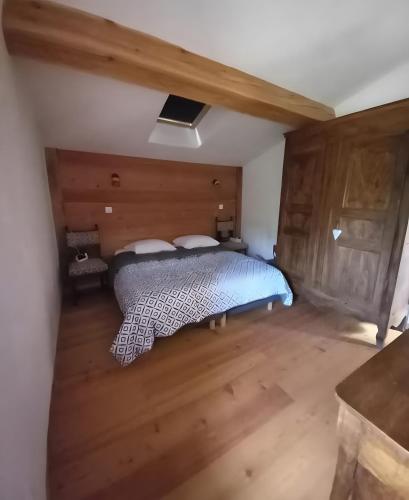 a bedroom with a bed in a room with wooden floors at Maison Le Petit Mas in Chabrillan