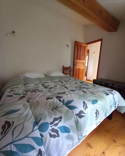 a bedroom with a bed with a blue and white comforter at Maison Le Petit Mas in Chabrillan