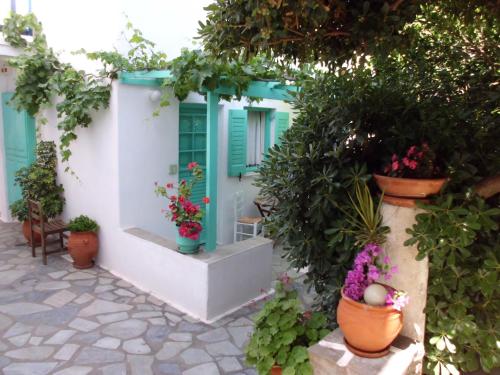 a house with flowers and plants in front of it at Aegean Village in Parikia