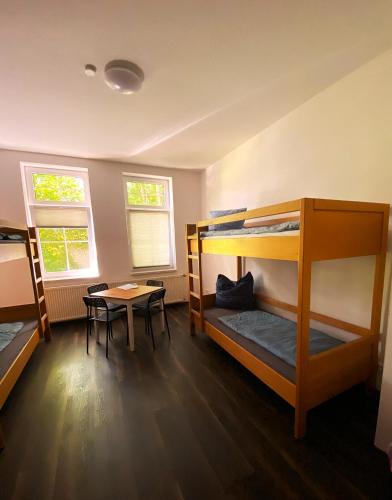 a room with two bunk beds and a table at Rennsteighostel in Ruhla