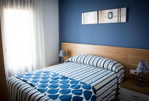 a bedroom with a bed with a blue wall at Casa Rural El Arco de los Arribes in Fermoselle