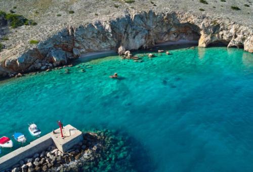 an aerial view of people swimming in the water near a cave at Casa Bellea in Belej