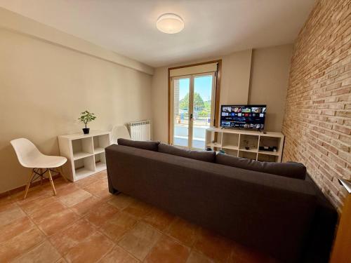 a living room with a couch and a tv at Apartamento con capacidad para 4 personas in Salvatierra de Miño