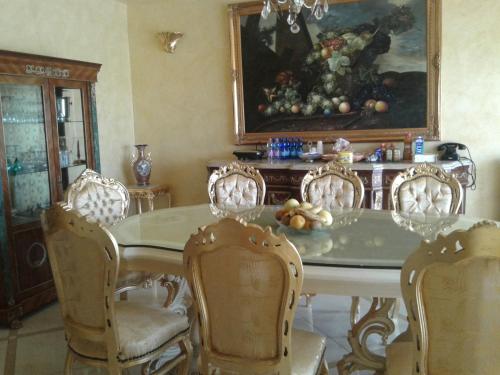 a dining room with a table and chairs and a painting at One M in Borgarello
