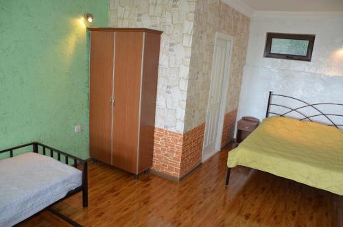 a room with two beds and a cabinet in it at TJ Guest House in Makhinjauri