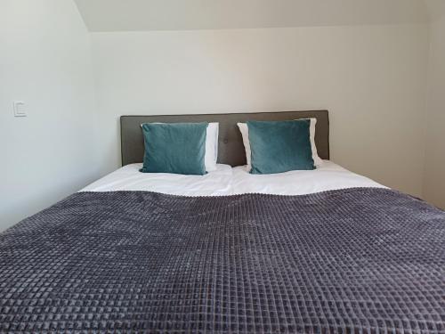 a bed with two blue pillows on top of it at Luise LuXe Suites in Tallinn