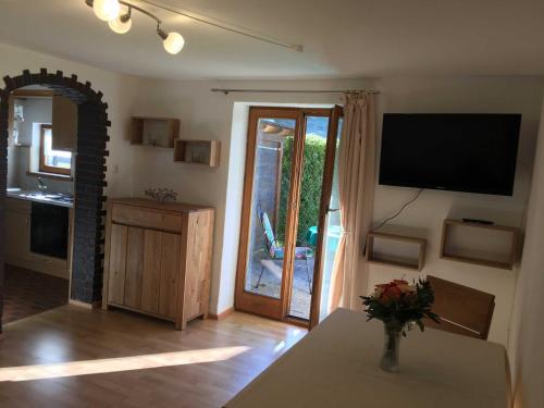 a living room with a table and a television and a door at Ferienwohnungen Familie Brunner, Kreuth-Reitrain in Oberach