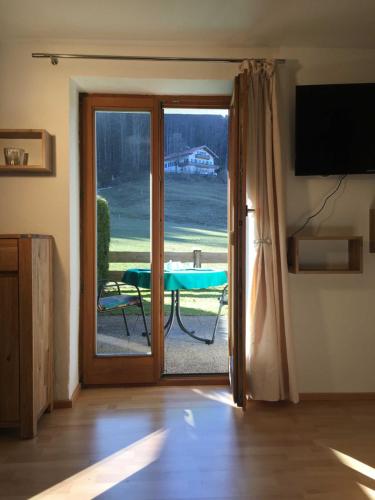 a door leading to a patio with a table outside at Ferienwohnungen Familie Brunner, Kreuth-Reitrain in Oberach