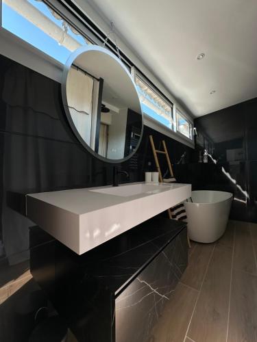 une salle de bain avec un lavabo blanc et un miroir dans l'établissement Appartement T1 centre ville sanary, plage à pied, quartier Portissol, à Sanary-sur-Mer