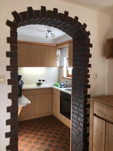 a kitchen with a brick wall in the middle of it at Ferienwohnungen Familie Brunner, Kreuth-Reitrain in Oberach