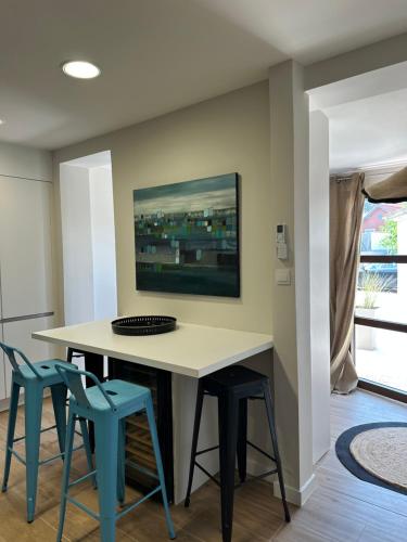 - une salle à manger avec une table et deux tabourets bleus dans l'établissement Appartement T1 centre ville sanary, plage à pied, quartier Portissol, à Sanary-sur-Mer