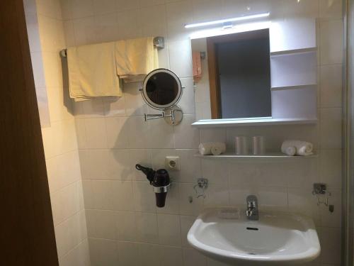 a bathroom with a sink and a mirror at Ferienwohnungen Familie Brunner, Kreuth-Reitrain in Oberach
