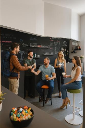 a group of people sitting around a bar with drinks at Bohoostel in Bologna