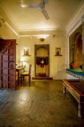 a living room with a table and a tv on the wall at Madri Haveli in Udaipur