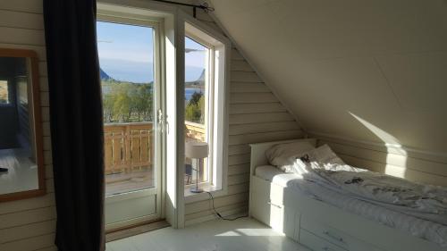 a room with a bed and a large window at Holiday Home Lofoten in Lyngværet