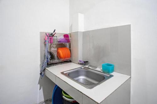 a small kitchen with a sink in a counter at Hotel O Almahyra Guest House Syariah in Jambi