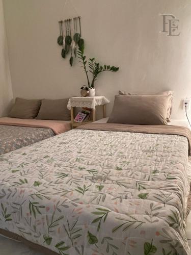 a bedroom with a large bed and a plant on the wall at Bé Homestay in Hai Phong