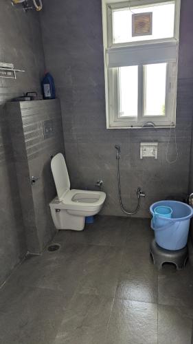 a bathroom with a toilet and a sink and a window at Mayur Home Stay, Morni Hills in Morni
