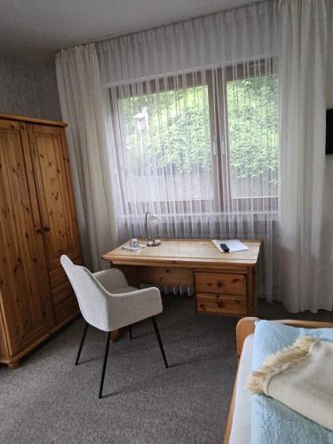 a bedroom with a desk and a chair in front of a window at Haus Hubertus in Winterberg