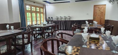 een eetkamer met houten tafels en stoelen bij Adventure Sarai Skardu in Skardu