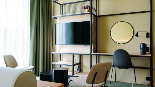 a living room with a tv and a mirror at Citybox Kristiansand in Kristiansand