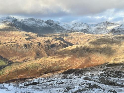 a snowy mountain range with snow covered mountains at The Old School House - Eskdale in Holmrook