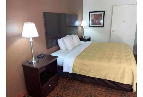 a hotel room with a large bed and a lamp at Motel 6 Oklahoma City OK Fairgrounds West in Oklahoma City