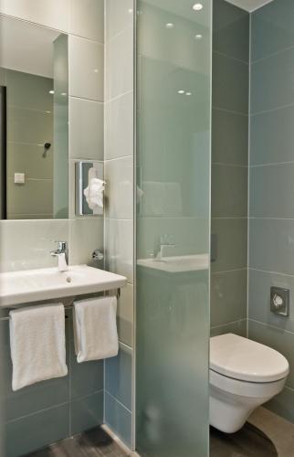 a bathroom with a toilet and a sink and a shower at Super 8 by Wyndham Munich City North in Munich