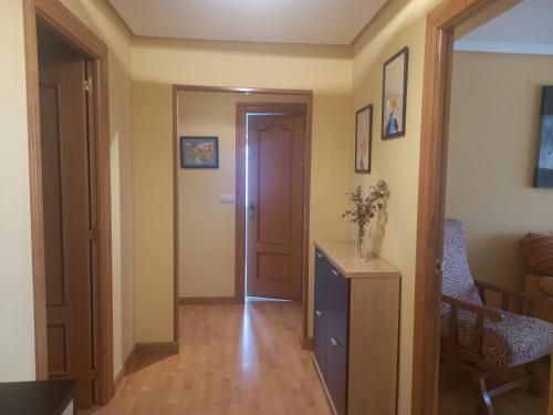 a hallway with a door and a table and a chair at Apartamento Sopuente in Selaya