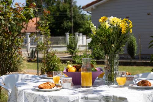 a table with a vase of flowers and food on it at Maison avec jardin in Aire-sur-lʼAdour