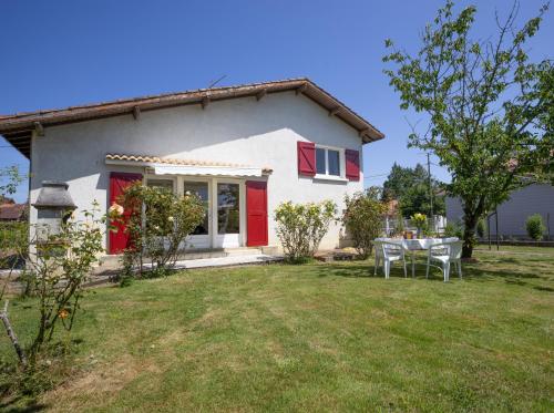 a small white house with a table in the yard at Maison avec jardin in Aire-sur-lʼAdour